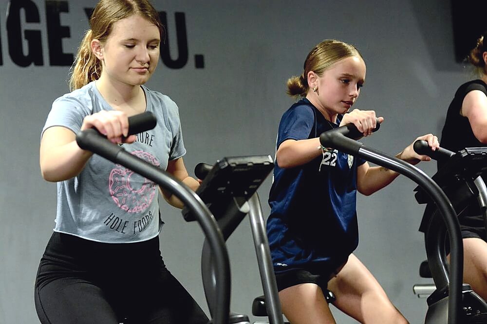 Youth athletes training on air bikes