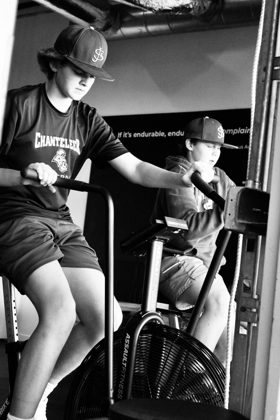 Young baseball players conditioning on air bikes